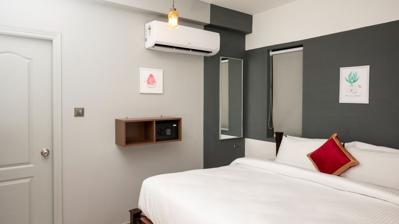 The bedroom with an LED TV, an AC and grey walls