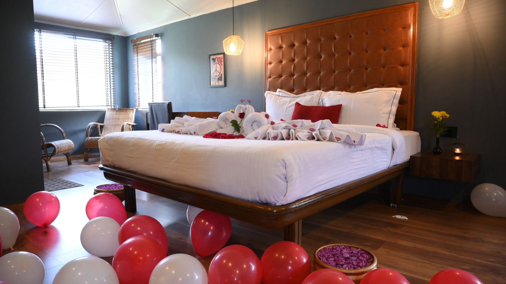 Elegant hotel room with red heart-shaped balloons and a spacious bed