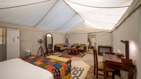 The interiors of the premium camps are equipped with a comfy bed, desk and other amenities - Karwaan Jaisalmer