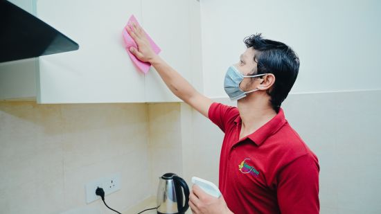 Lime Tree Hotel Golf Course Extension Road Gurgaon - A staff cleaning the cupboard in the kitched in lieu of the covid 19 protocols