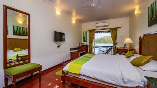 A double bed tv ac and balcony inside Cones room at neemrana s three waters