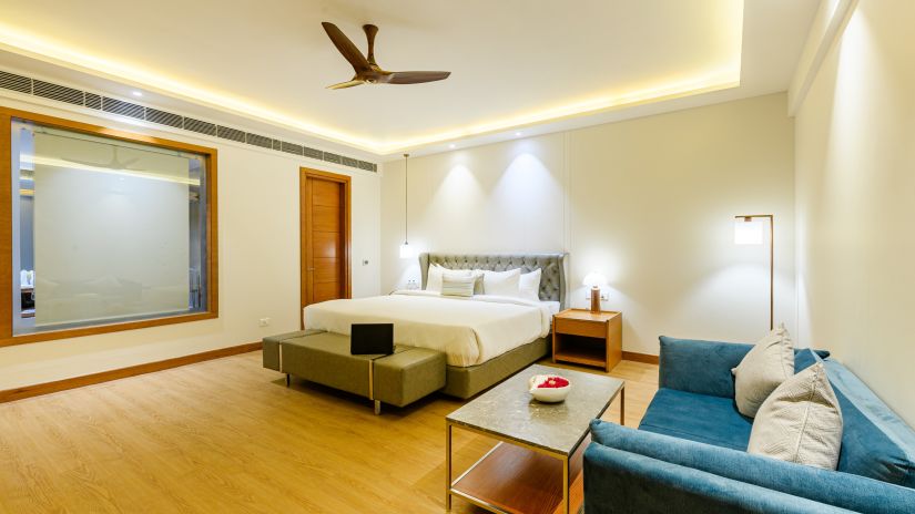 Interiors of one of the bedrooms at our presidential suite in Pushkar featuring a bed, a blue sofa and other furniture 57