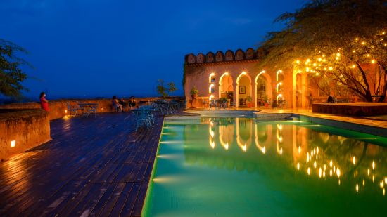 A vibrant blue pool with the resort at the background - Hill Fort Kesroli Alwar Rajasthan