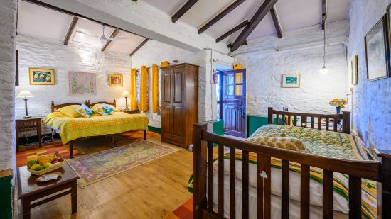 The Ramgarh Bungalows - Lemon Room featuring a queen size bed and a single bed with a warorbe and wooden ceiling