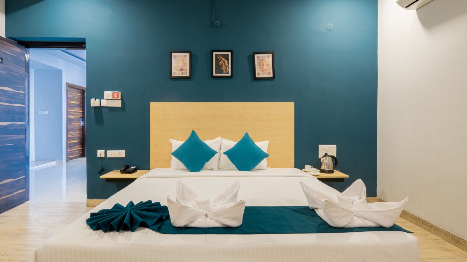 Image of the standard room with a bed and white and blue pillows.