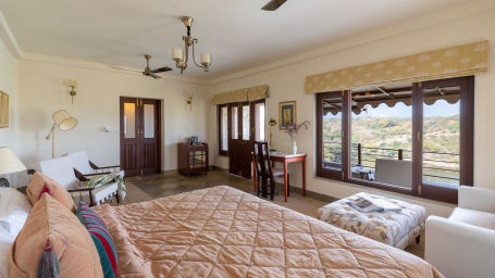 a king bed with a futon in front of it with sofas on the side inside a room - Chunda Shikar Oudi, Udaipur