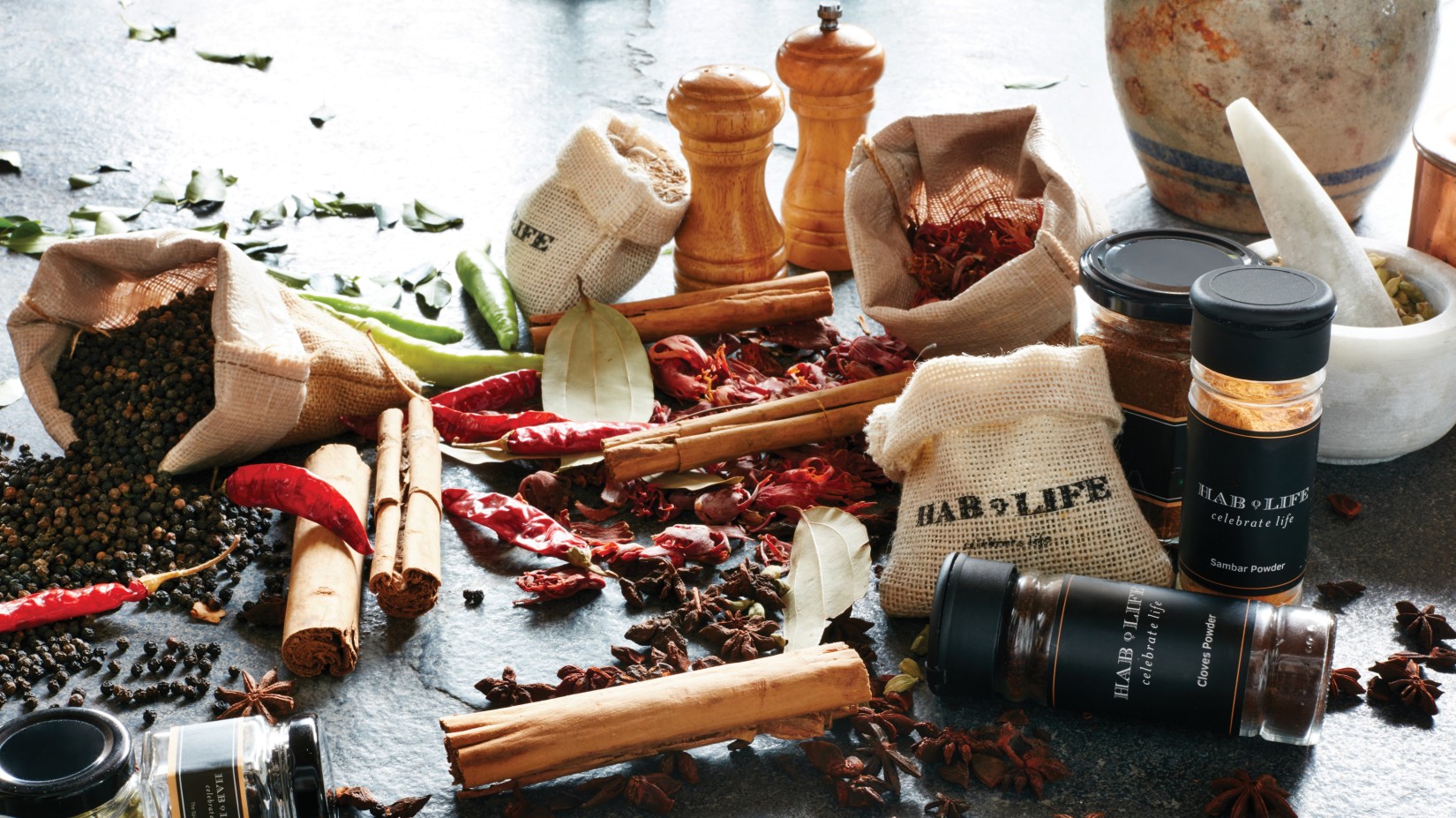 Jars of food items and spices on a table at Hablis Hotel, Chennai