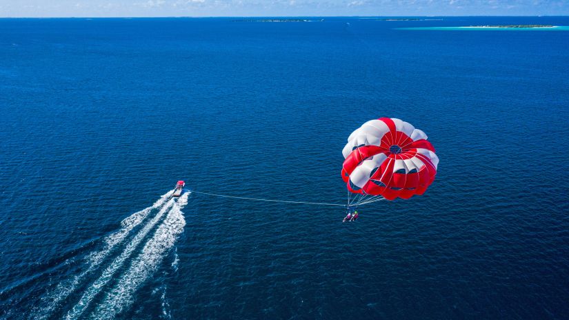 An individual enjoying parasailing with beautiful view of sea in the background