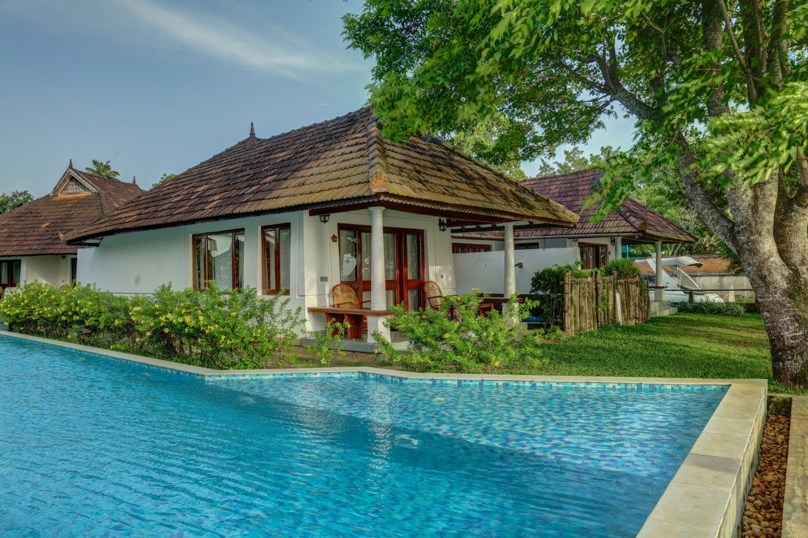 bunch of cottages surrounded by a swimming pool - Rhythm Kumarakom