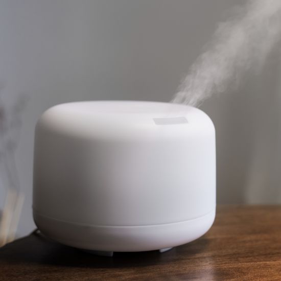 aroma humidifier therapeutic kept inside a room on a wooden table