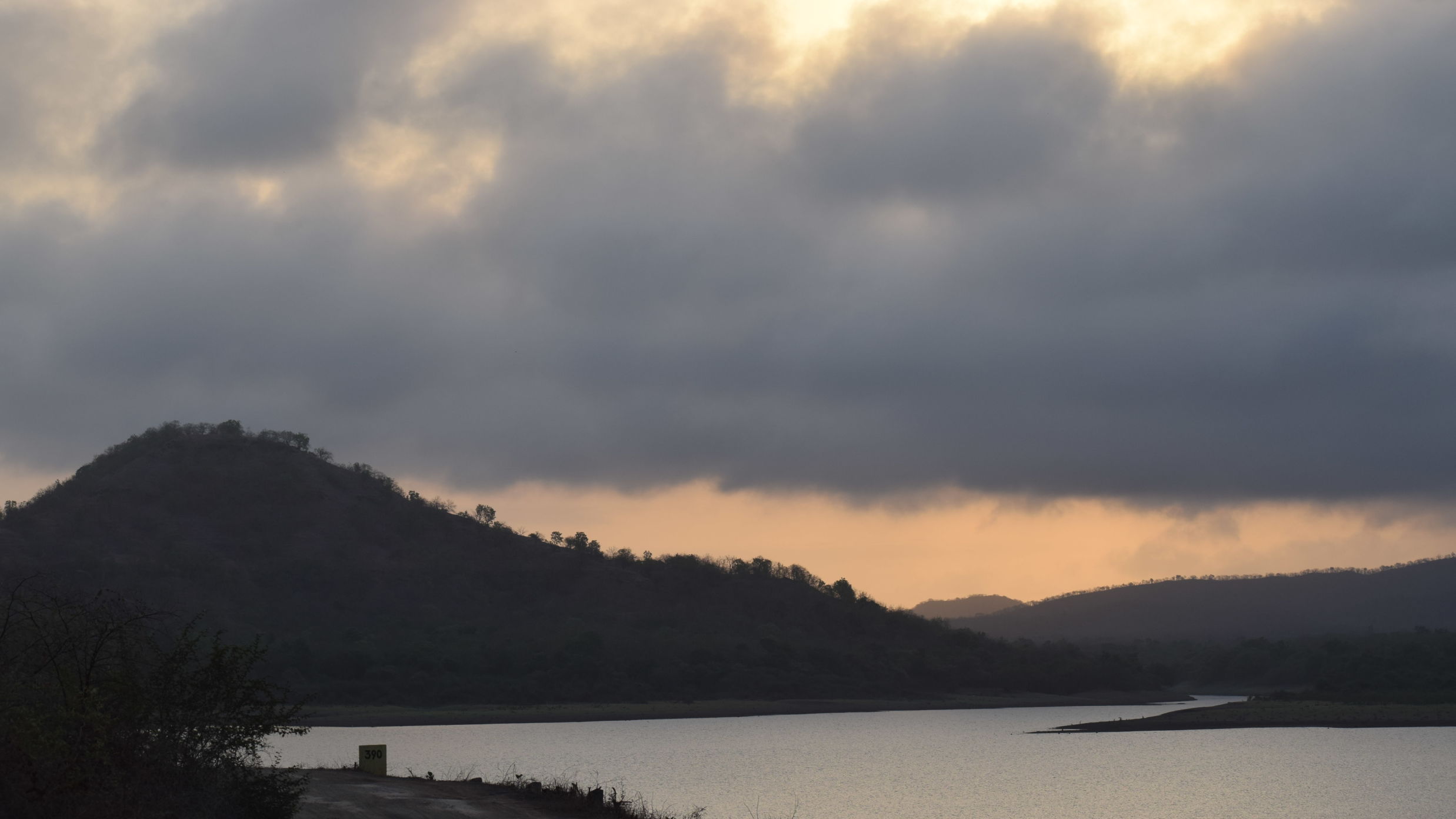 scenic view of a sunset that features hills and a lake