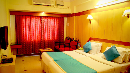 an air-conditioned room decked with a bed, seating arrangements and television - Hotel Swagath, Bangalore