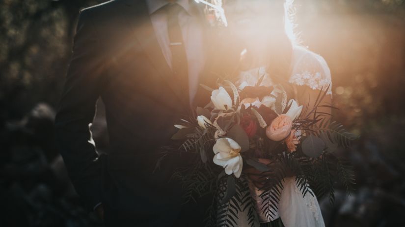 a close up shot of a couple where the bride is holding a bouquet