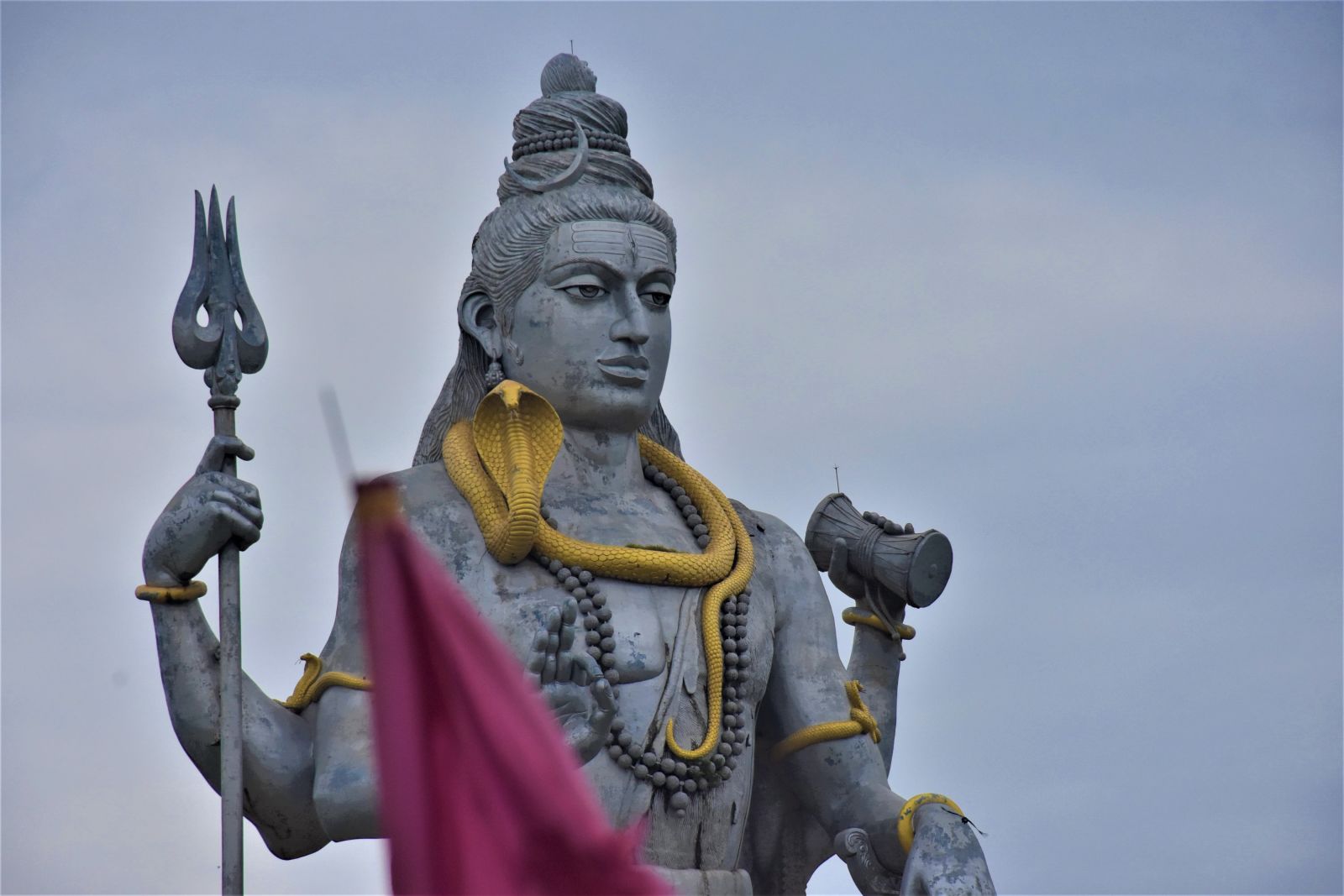 a statue of shiva holding a trident and a damru