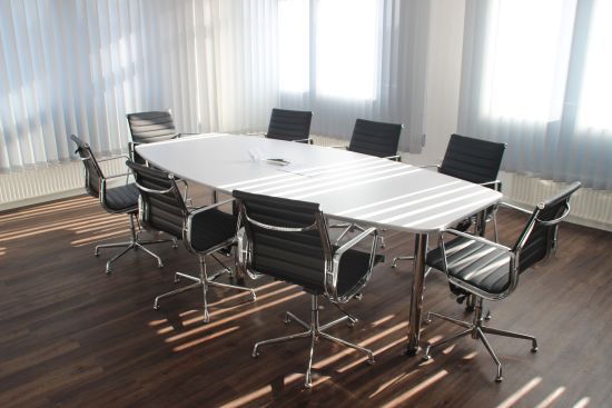 alt-text The meeting room has a small white table surrounded by chairs