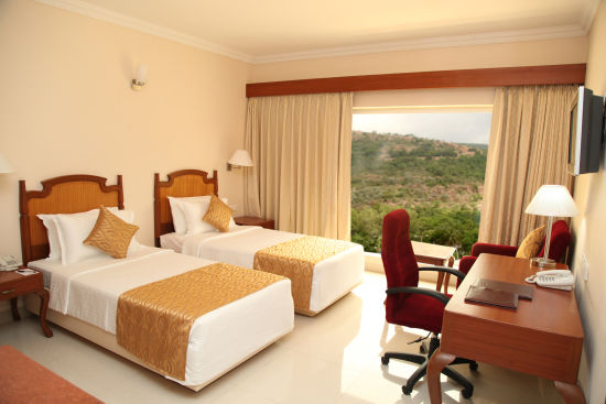 alt-text twin beds with a study table in front of it in superior rooms in Tirupati - Raj Park Hotel, Tirupati