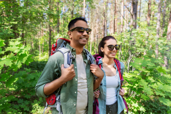 alt-text a man and a woman geared up for activities amidst lush green forest