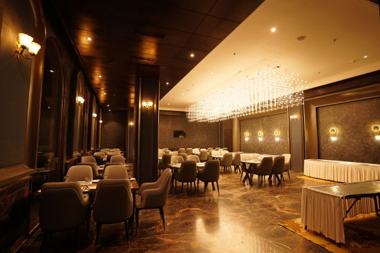 alt-text restaurant with tables and chairs with warm lighting at Classic Sapphire by Ananta