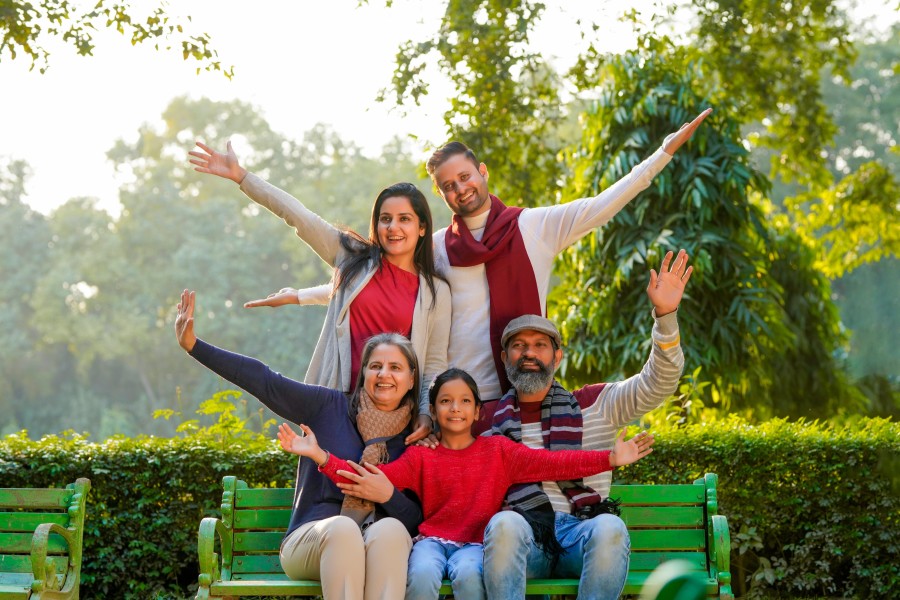 alt-text a family posing for the camera on a bench with a lush green backdrop