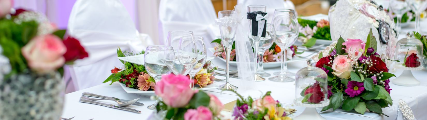 a table decorated with flowers at an event hall for a party