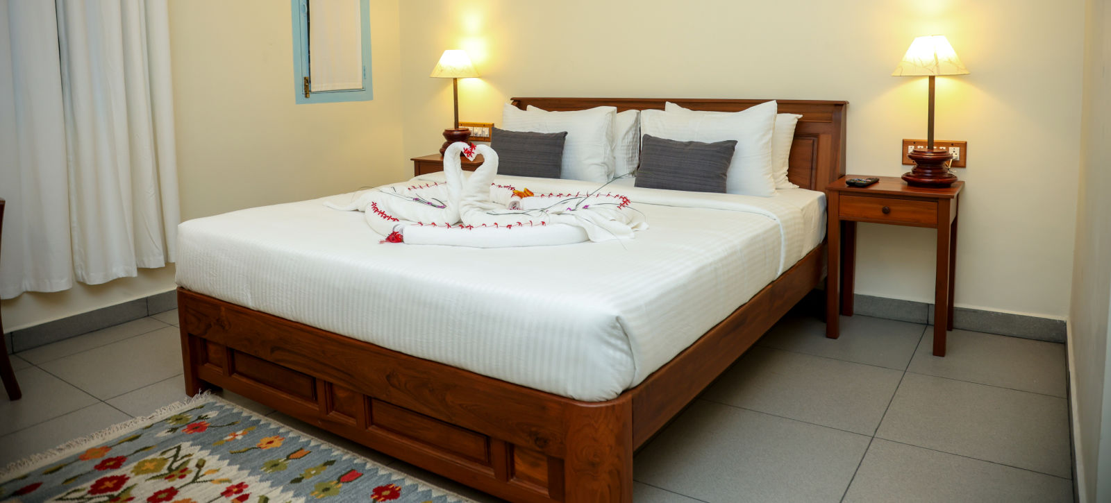 A bedroom which has a bed decorated by towel swans | Mango HIll La Serene, Ponicherry