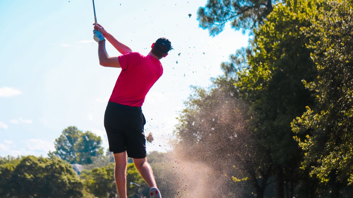 a golfer in full swing after taking the shot 