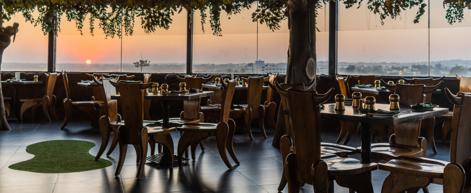 Seating arrangement in a restaurant at The President Hotel, Hubli during sunset