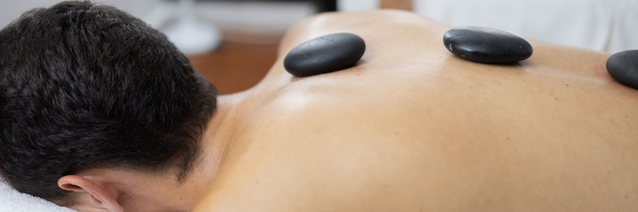 a person getting a hot stone therapy at the spa - The Soco House