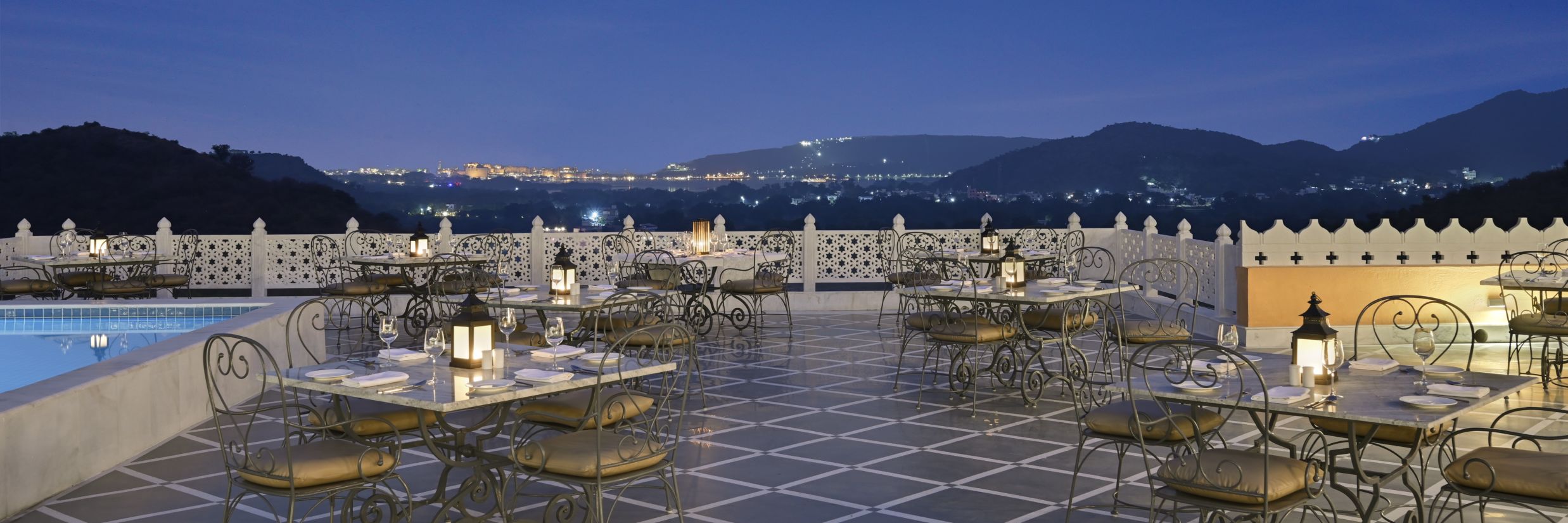 Fateh Vilas Udaipur - view of the terrace containing numerous tabes and chairs set up by the swimming pool