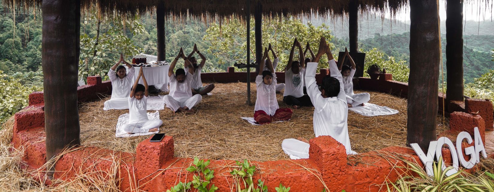 people practicing yoga inside the yoga centre - Holistic Stay Eco Resort, Kannur