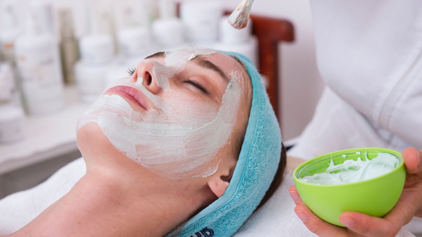 A person receives a facial treatment at a spa