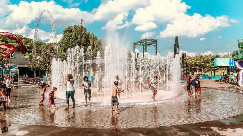 People palying around a water fountain in a water park