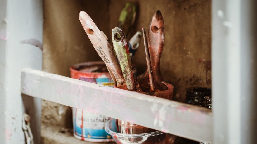 a close up shot of many paint brushes kept inside a small bucket