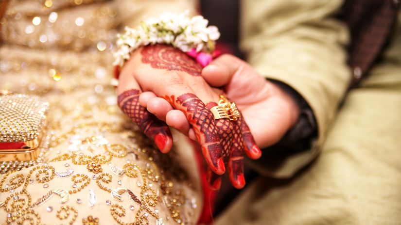 A closeup shot of a couple holding hands after their wedding 