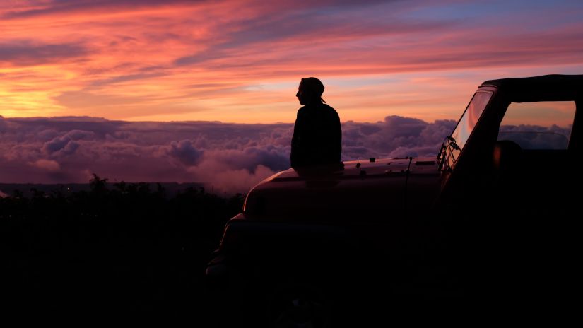 person sitting on the hood of a car