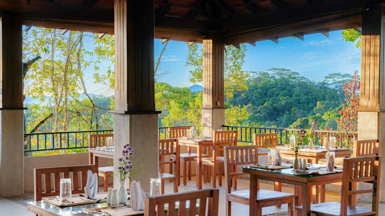 Chairs and tables in an al fresco restaurant with a mountain view | Celestial Hills, Kandy