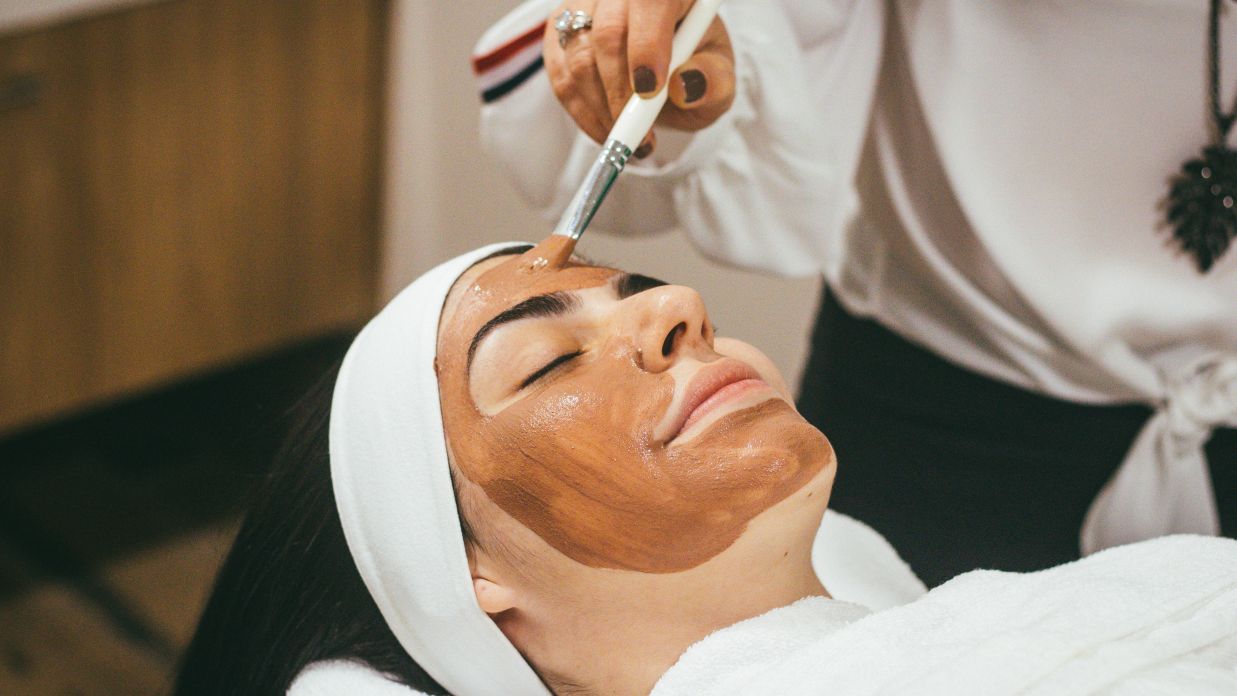 a person applying face mask on a woman