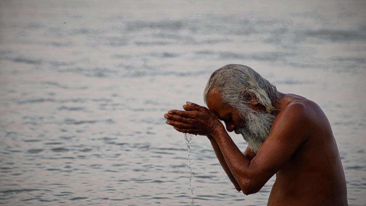 A man praying in Triveni Ghat@ Lamrin Boutique Cottages, Rishikesh