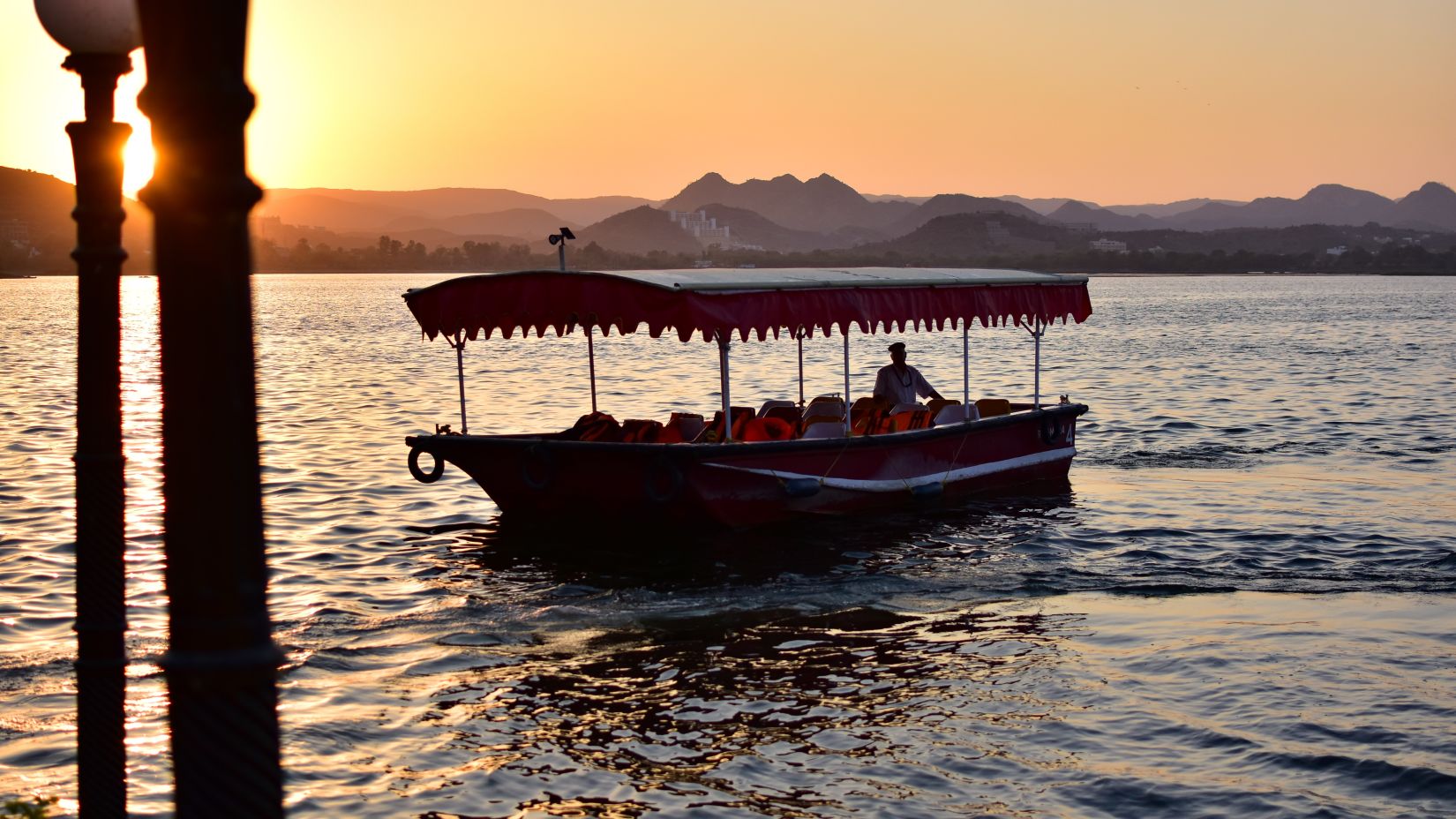 A lonely boat in the lake with sunset in the background- Udaipur 