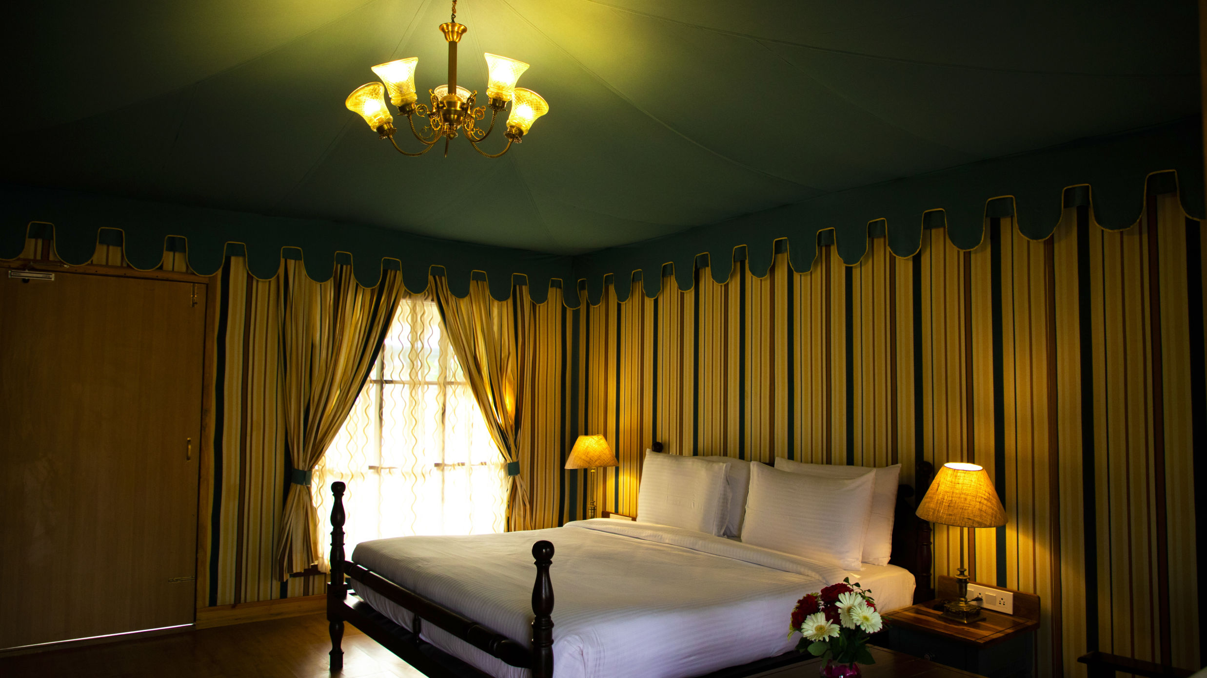 A white bed surrounded by walls with patterns of vertical lines