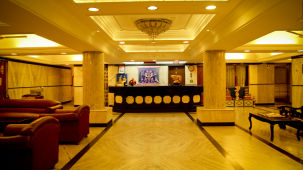  Hotel Yasodha Towers - Interior view of the lobby area featuring supporting pillars and sofas in yellow lighting