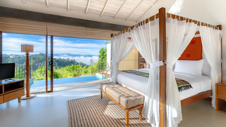 A room with a canopy bed, TV and a huge glass window | Celestial Hills - Villas & Suites in Kandy