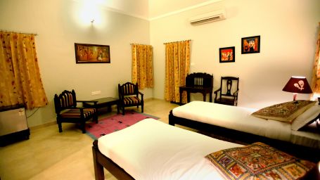 Room Interior with twin beds and chairs at Clarks Exotica Resort