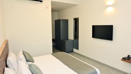 Well lit Standard Room with a double bed and television - Clarks Inn Express, KRS Road, Mysore