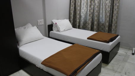 bedroom with twin beds having brown blankets at Click White House