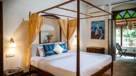 four poster bed with yellow curtains  @ Lamrin Ucassaim Hotel, Goa