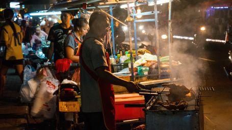 Image depicting a street food destination with several stalls