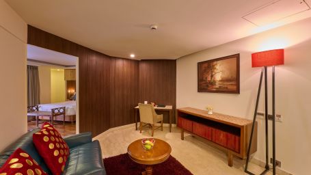 A living space featuring a sofa, pillows, a coffee table, a lamp and a wall painting - Renest Dunsvirk Court Mussoorie