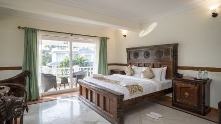 Premium Riverview Bedroom features an a comfy bed with a wooden frame and a balcony - Stone Wood Riverfront Resort, Siolim