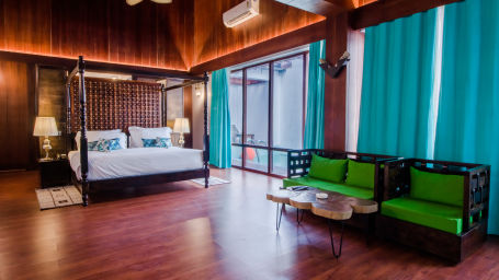 an overview of the Beach Mansion with a king bed in the centre and a tv and sofa on either side - Symphony Summer Sand Beach Resort And Spa, Neil Island